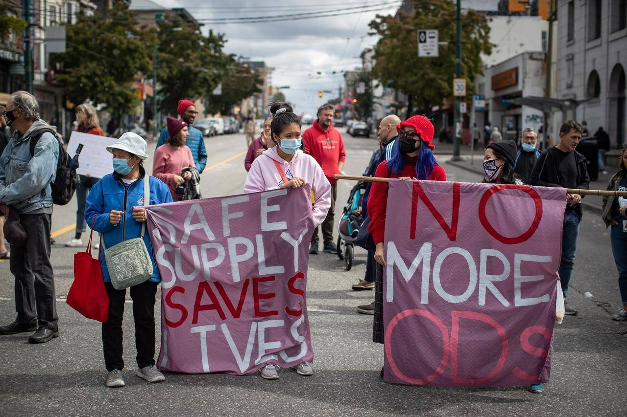 People hold banners during a march to remember those who died during the overdose crisis and to call for a safe supply of illicit drugs on International Overdose Awareness Day, in Vancouver, on Tuesday, August 31, 2021. Advocates for a safe drug supply gathered in Vancouver’s Downtown Eastside to denounce the recent arrests of the founders of the Drug User Liberation Front. THE CANADIAN PRESS/Darryl Dyck
