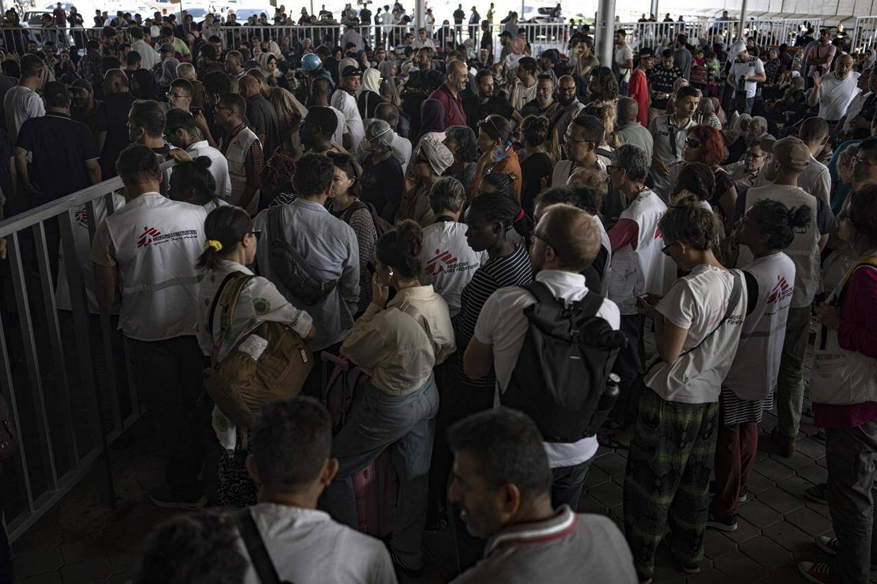 Palestinians and foreign aid workers wait to cross into Egypt at Rafah, Gaza Strip, on Wednesday, Nov. 1, 2023. Canadians looking to flee Gaza continue to await confirmation on when they can cross into Egypt, with no official announcement yet from Global Affairs Canada on a date or time, one month after the latest Israel-Hamas war began. THE CANADIAN PRESS/AP-Fatima Shbair