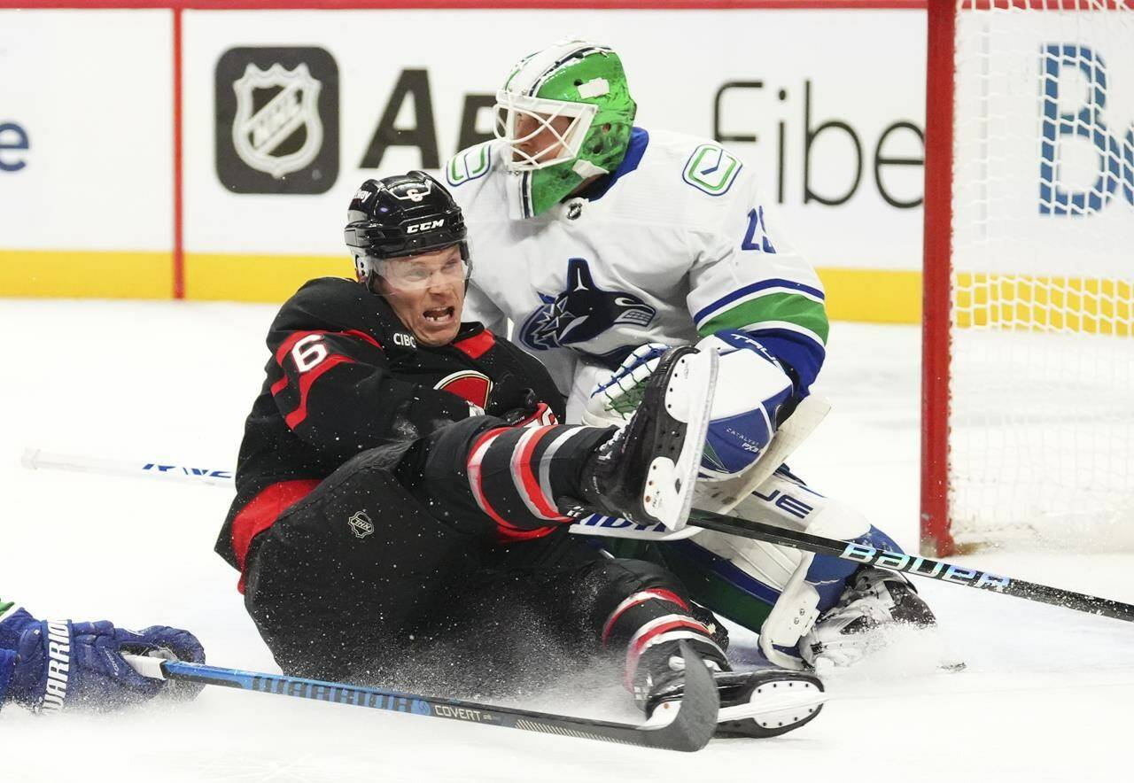 Ottawa Senators defenceman Jakob Chychrun (6) slams into Vancouver Canucks goaltender Casey DeSmith (29) during first period NHL hockey action in Ottawa on Thursday, Nov. 9, 2023. THE CANADIAN PRESS/Sean Kilpatrick