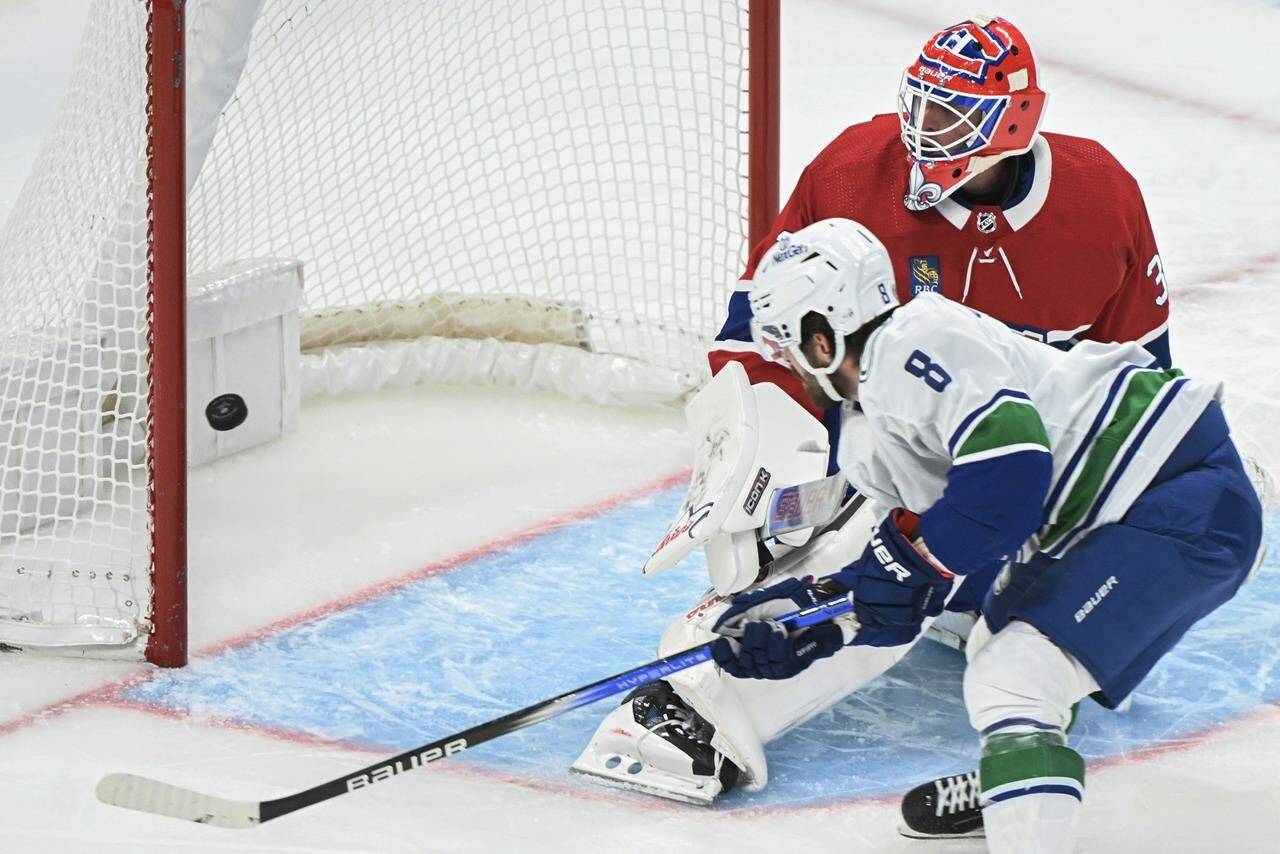 Vancouver Canucks’ Conor Garland scores against Montreal Canadiens goaltender Jake Allen during second period NHL hockey action in Montreal, Sunday, November 12, 2023. THE CANADIAN PRESS/Graham Hughes