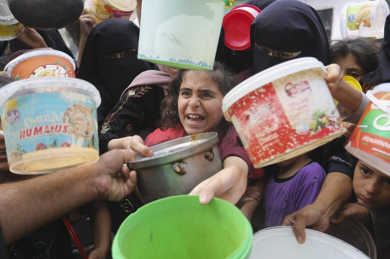 Palestinians line up for food during the ongoing Israeli bombardment of the Gaza Strip in Rafah on Monday, November 13, 2023. (AP Photo/Hatem Ali)
