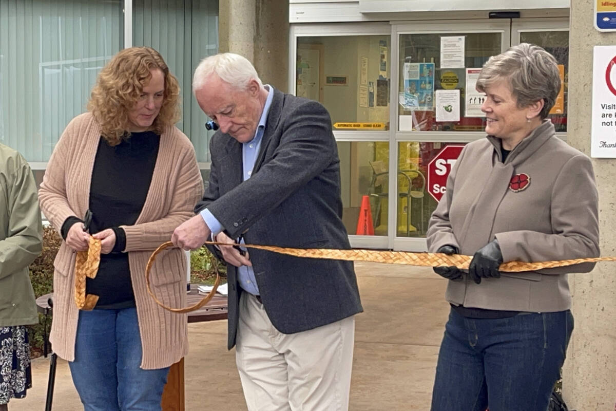 West Coast General Hospital Foundation president Robbie O’Dwyer cuts a piece of ceremonial cedar ribbon at the official opening of the new emergency department, Nov. 10, 2023. Mid Island-Pacific Rim MLA Josie Osborne, right, waits her turn. (SUSAN QUINN/ Alberni Valley News)