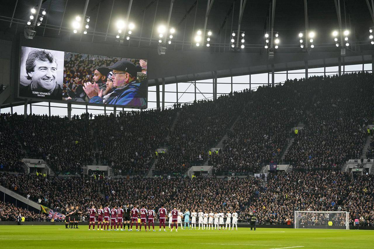 Players and fans applaud during a tribute to former England player and coach Terry Venables,shown on the video screen, before the English Premier League soccer match between Tottenham Hotspur and Aston Villa at the Tottenham Hotspur stadium in London, Sunday, Nov. 26, 2023. Venables has passed away, it was announced Sunday. (AP Photo/Kirsty Wigglesworth)