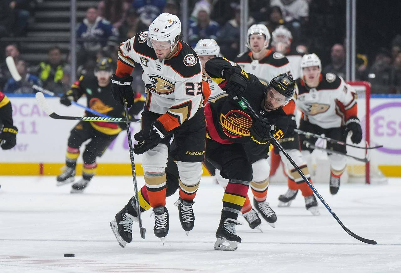 Anaheim Ducks’ Mason McTavish (23) and Vancouver Canucks’ Teddy Blueger (53) vie for the puck during the second period of an NHL hockey game in Vancouver, on Tuesday, Nov. 28, 2023. THE CANADIAN PRESS/Darryl Dyck