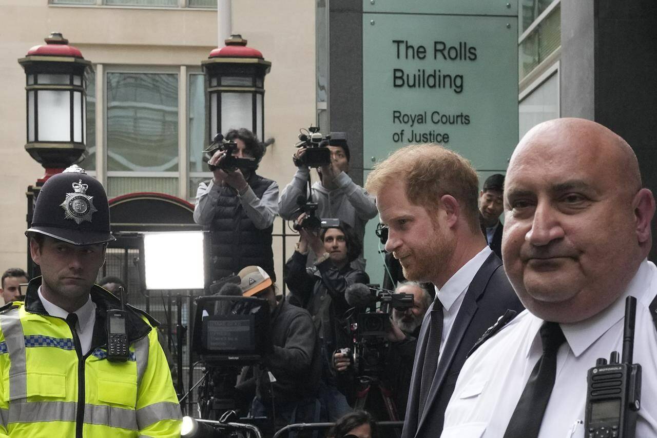 FILE - Prince Harry, second from right, escorted by security leaves the High Court after giving evidence in London, Tuesday, June 6, 2023. Prince Harry is challenging on Tuesday, Dec. 5, 2023, the British government’s decision to strip him of his security detail after he gave up his status as a working member of the royal family and moved to the United States. The Duke of Sussex said he wants protection when he visits home and claimed it’s partly because an aggressive press jeopardizes his safety and that of his family. (AP Photo/Frank Augstein, File)