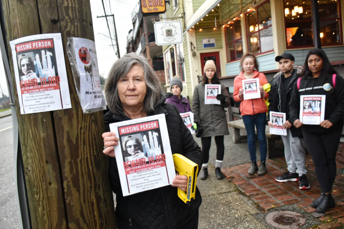 Debbie Harbowy, mother of Rebecca Harbowy, 36, who has been missing since Nov. 23, with part of a search crew handing out posters Wednesday afternoon in the area surrounding the Billy Miner Ale House and Café. (Colleen Flanagan/The News)