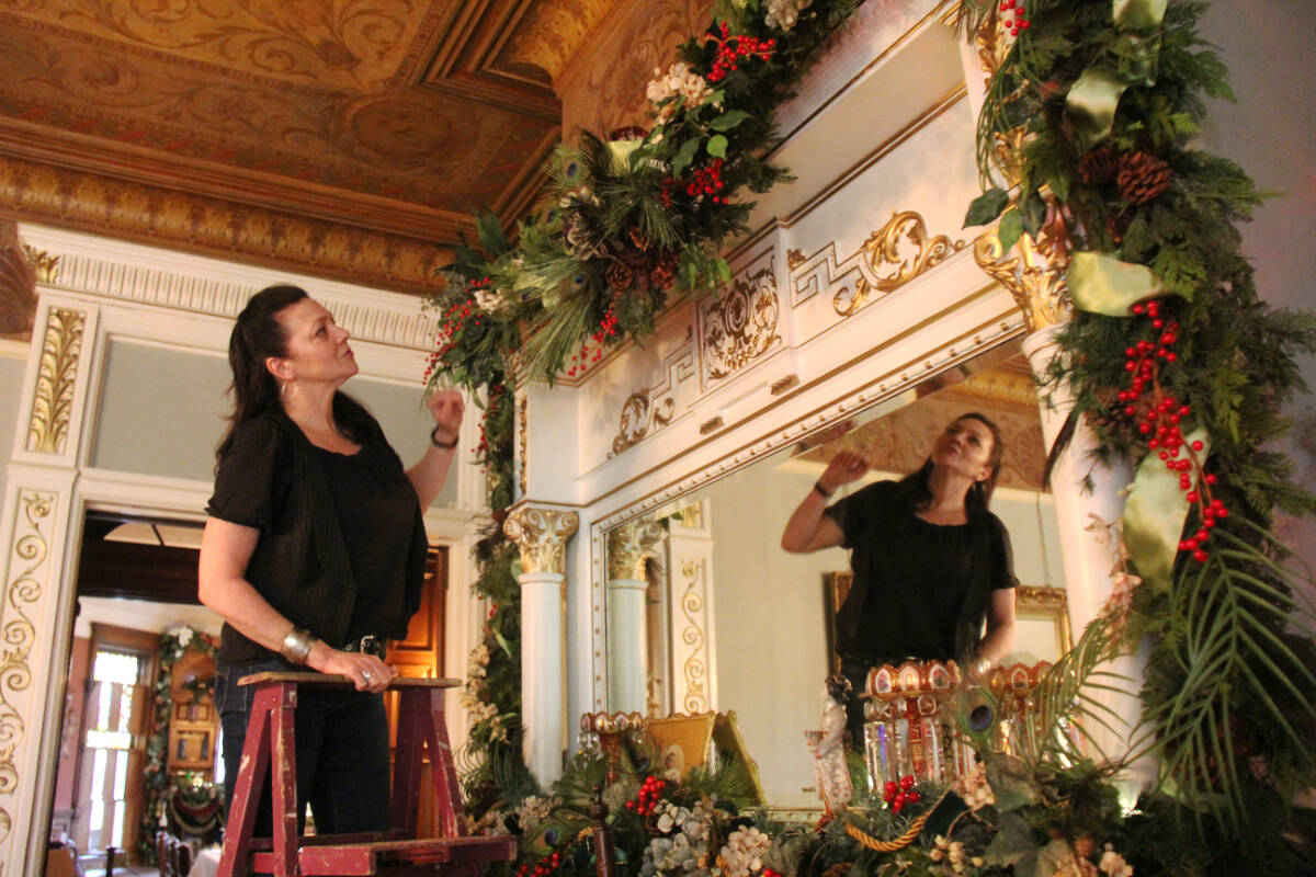 Designer Sherry Kerr fine tunes a mantel at Victoria’s Craigdarroch Castle to prepare for Christmas. (Christine van Reeuwyk/News Staff)
