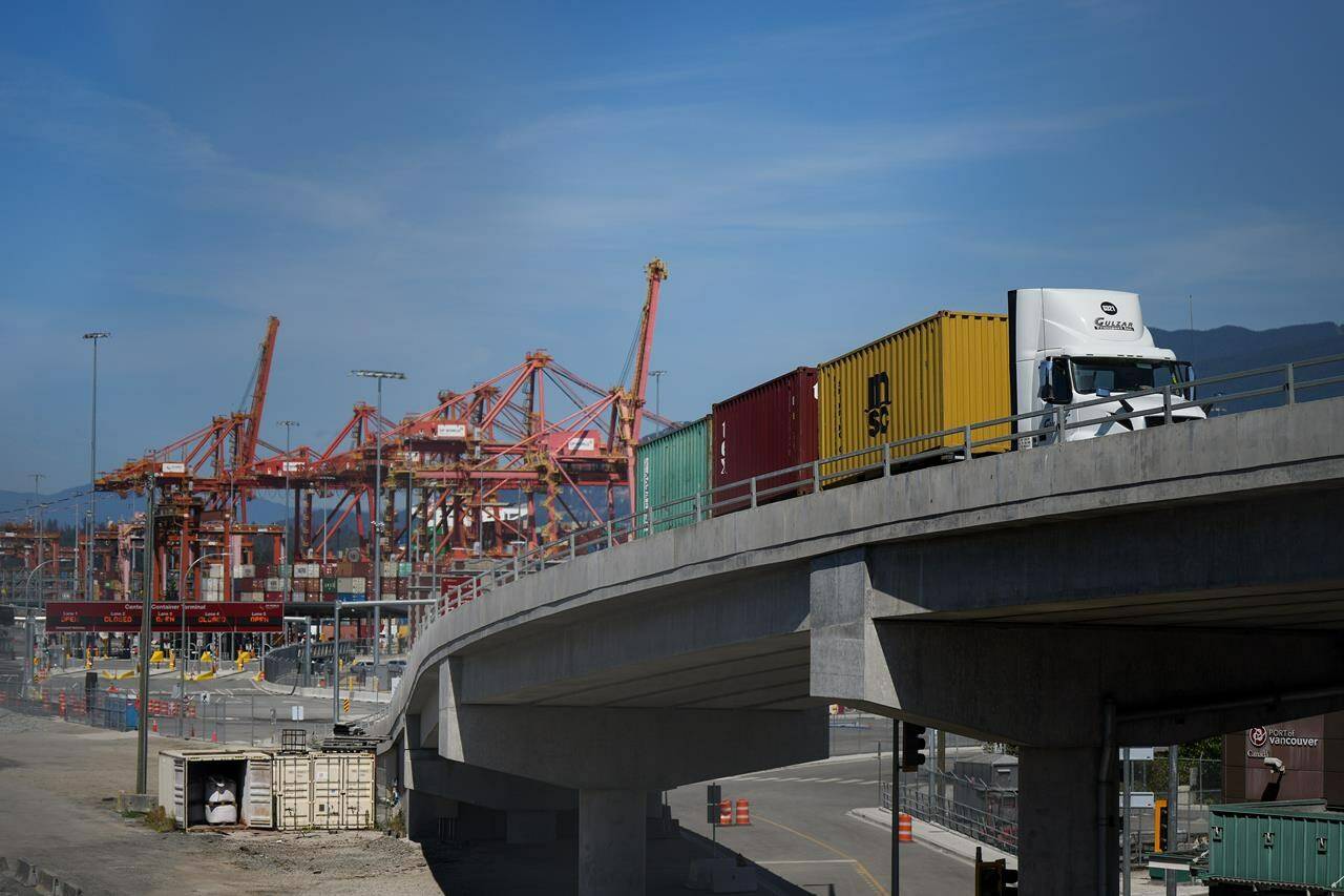 The British Columbia government is stepping up penalties for truckers who crash into highway overpasses after a rash of such incidents in recent years. A transport truck carries cargo containers from the Centerm Container Terminal at port in Vancouver, on Friday, July 14, 2023. THE CANADIAN PRESS/Darryl Dyck