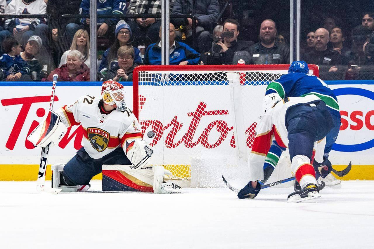 Vancouver Canucks’ Brock Boeser (6) scores on Florida Panthers goaltender Sergei Bobrovsky (72) as Panthers’ Niko Mikkola (77) defends during the second period of an NHL game in Vancouver on Thursday, Dec. 14, 2023. THE CANADIAN PRESS/Ethan Cairns