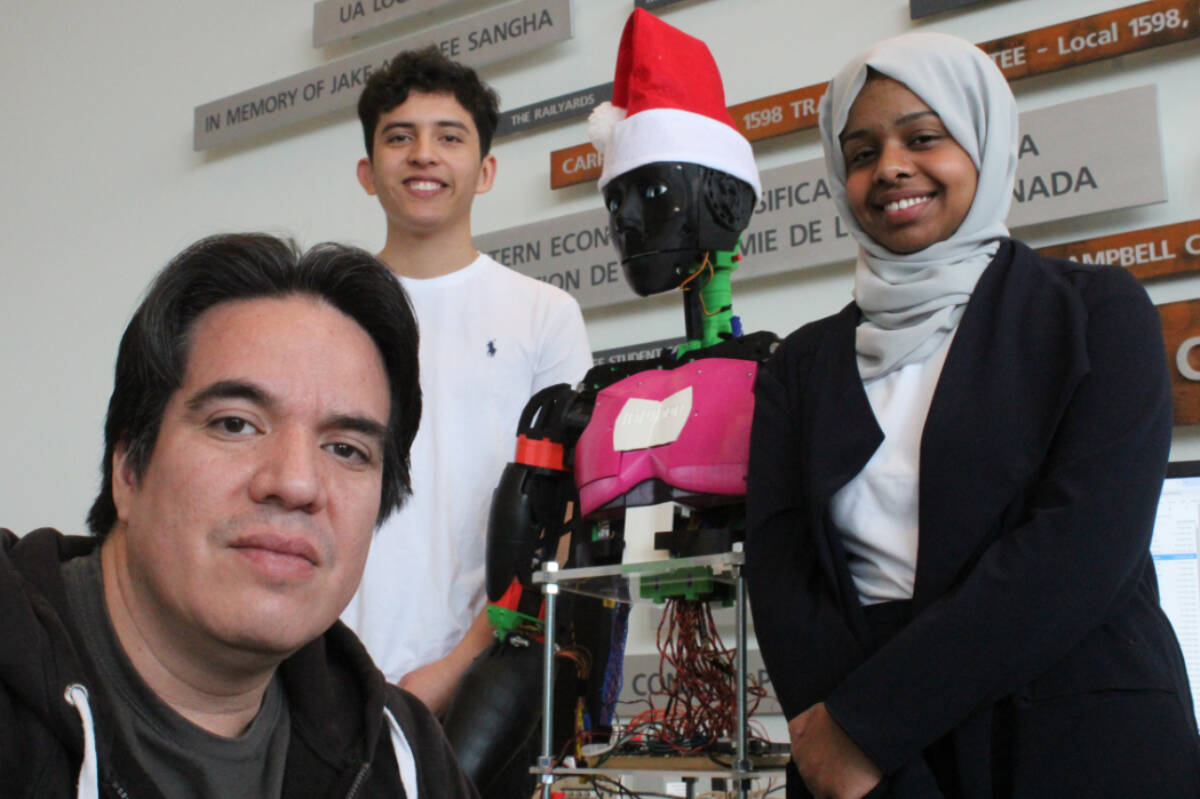 Left to right, Sebastian Medina, Juan Ochoa and Sama Osman display the Hanoi Droid they have been working on for four months. (Ella Matte/News Staff)