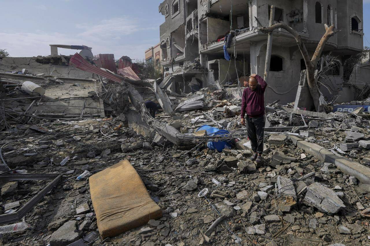 Palestinians inspect the rubble of a building of the Al Nawasrah family destroyed in an Israeli strike in Maghazi refugee camp, central Gaza Strip, Monday, Dec. 25, 2023. (AP Photo/Adel Hana)