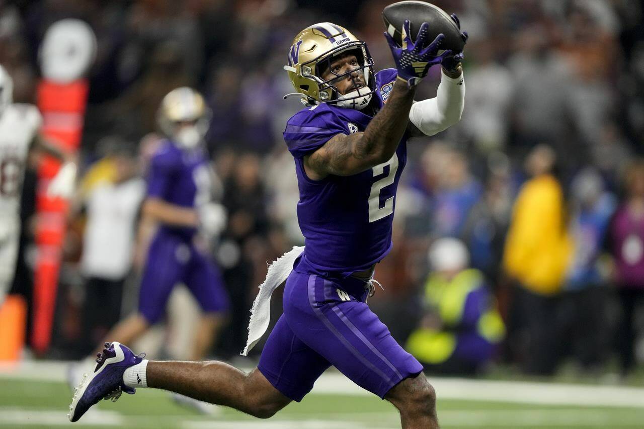 Washington wide receiver Ja’Lynn Polk (2) makes the catch for a touchdown against Texas during the first half of the Sugar Bowl CFP NCAA semifinal college football game, Monday, Jan. 1, 2024, in New Orleans. (AP Photo/Gerald Herbert)