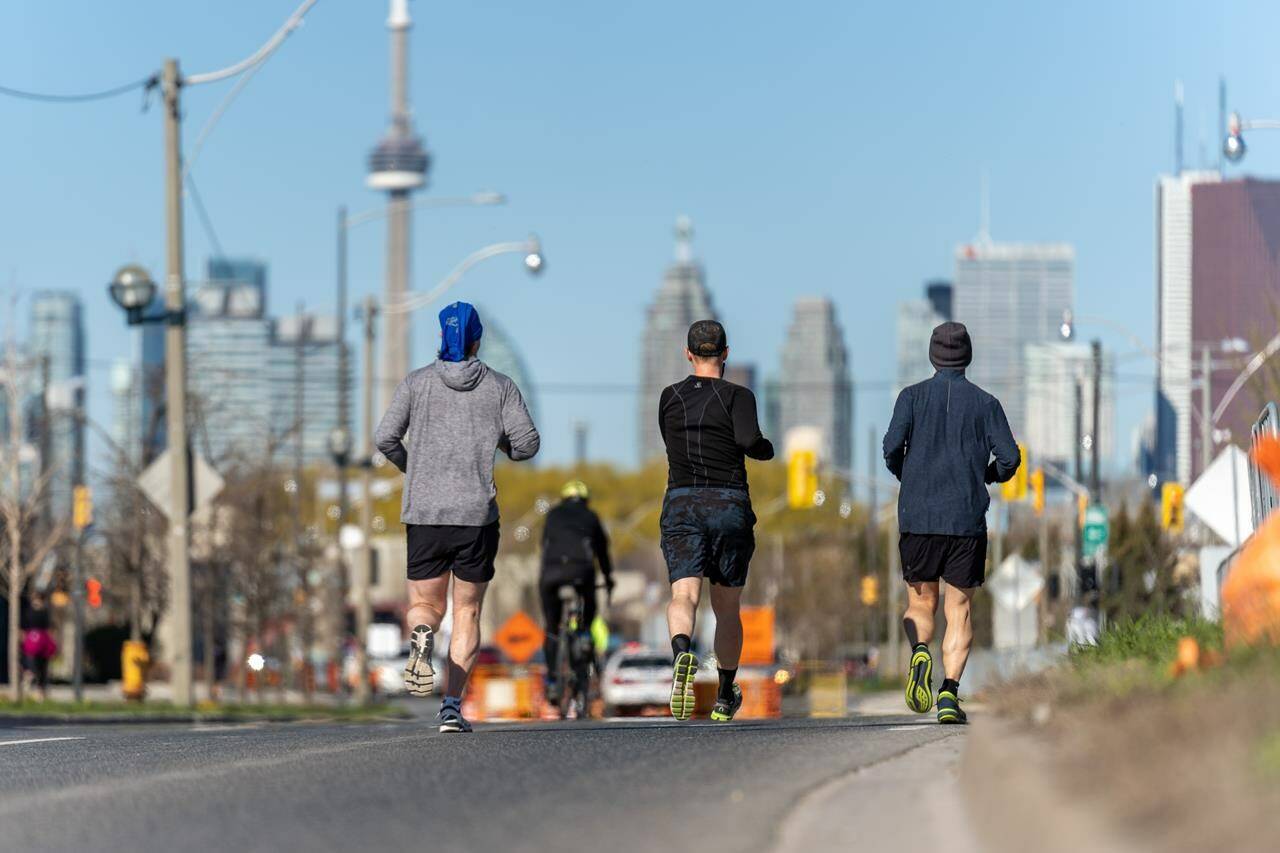 A group of runners run along Lake Shore Blvd. in Toronto on Saturday, May 1, 2021. A battle has broken out over the sidewalks in Canada’s most populous city. THE CANADIAN PRESS/Yader Guzman