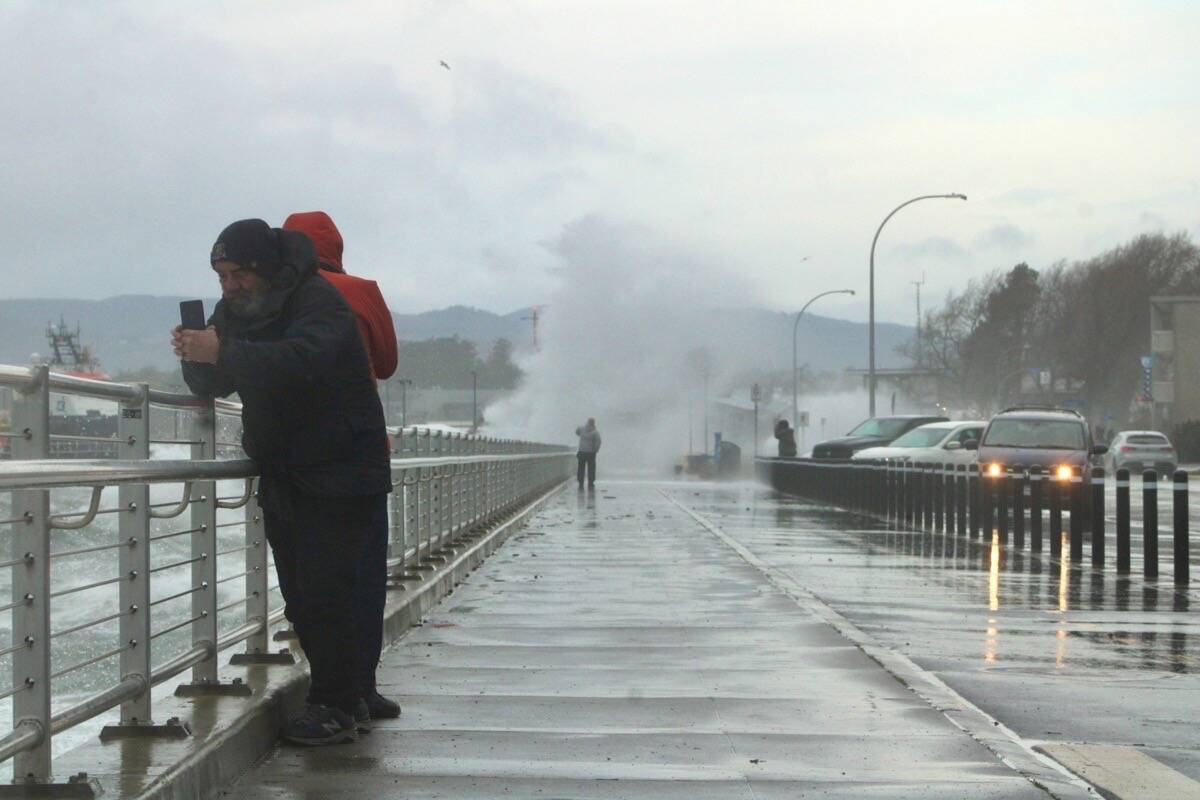 Waves wash over Dallas Road and storm watchers in Victoria on Jan. 9. Wind and waves prompted the Greater Victoria Harbour Authority to close both upper and lower paths of The Breakwater. (Jake Romphf/News Staff)