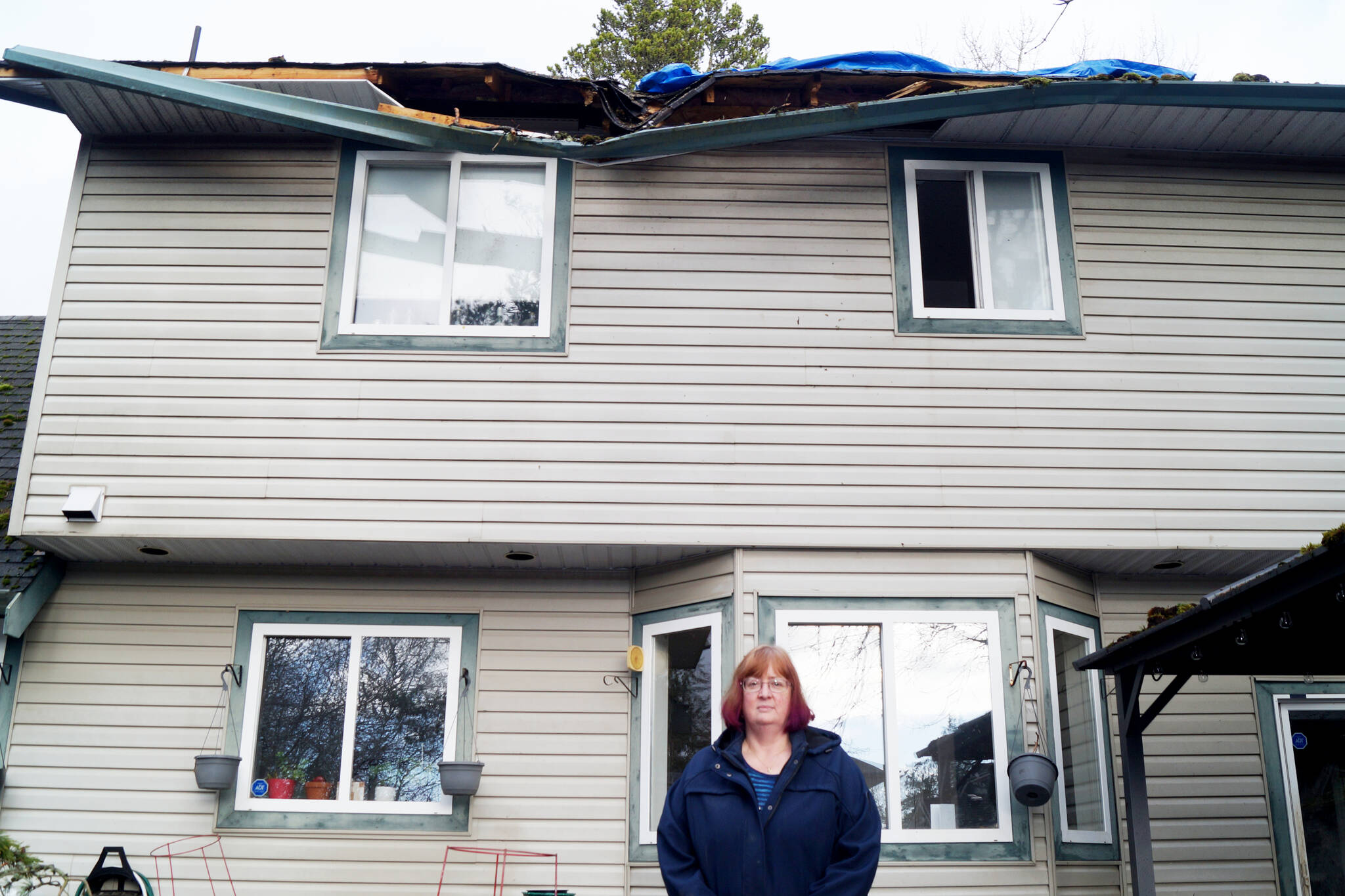 Stephanie Lumley stands under where a tree hit the roof of her home and left a large branch sticking through the ceiling. (Rick Stiebel- Sooke News Mirror)