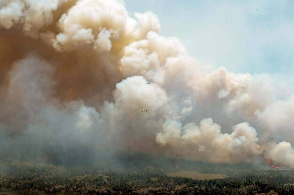 Charges have been laid against a 22-year-old Nova Scotia man for lighting a fire last May that grew to become the largest wildfire in the province’s history. In this aerial image, an aircraft, centre, flies near a wildfire burning near Barrington Lake in Shelburne County, N.S., on Wednesday, May 31, 2023. THE CANADIAN PRESS/HO-Communications Nova Scotia **MANDATORY CREDIT**