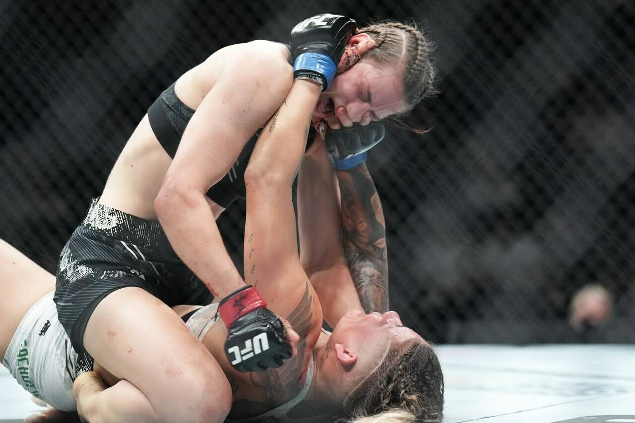 Jasmine Jasudavicius, top, fights Priscila Cachoeira during UFC 297 in Toronto on Saturday, Jan. 20, 2024. THE CANADIAN PRESS/Nathan Denette
