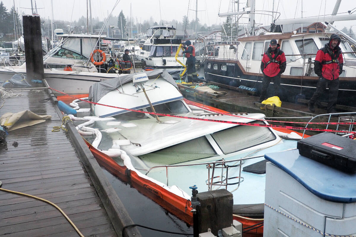 Efforts to protect the environment and recover a sunken boat at Stones Marina are being taken in Nanaimo on Monday, Jan. 22, after its owner was rescued by firefighters when the boat started taking on water on the weekend. (Chris Bush/News Bulletin)